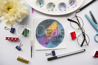 Inspirational quotes on space background. Artist s workspace with white chrysanthemum, glasses, watercolor, pencil, brush, scissors, miniature clothespins on a white background.