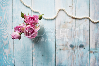Bouquet of pink roses on a wooden background with the place for your text.