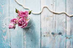 Bouquet of pink roses on a wooden background with the place for your text.