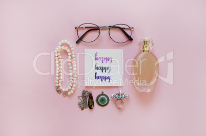 Happy handwritten with watercolor in calligraphy style. Women's fashion accessories arrangement on a pink background. Flat lay