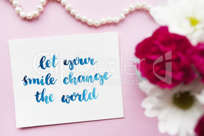 Inspirational quote Let your smile change the world written in calligraphy style with watercolor. Composition on a pink background. Flat lay