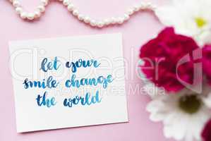 Inspirational quote Let your smile change the world written in calligraphy style with watercolor. Composition on a pink background. Flat lay