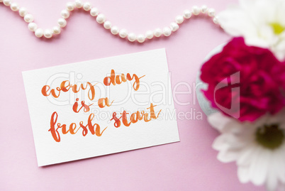 Inspirational quote Every day is a fresh start written in calligraphy style with watercolor. Composition on a pink background. Flat lay