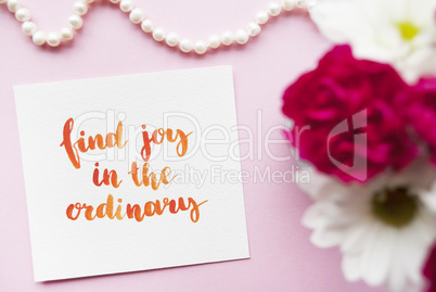 Inspirational quote Find joy in the ordinary written in calligraphy style with watercolor. Composition on a pink background. Flat lay
