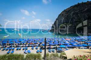Badestrand mit blauen Sonnenschirmen in Italien