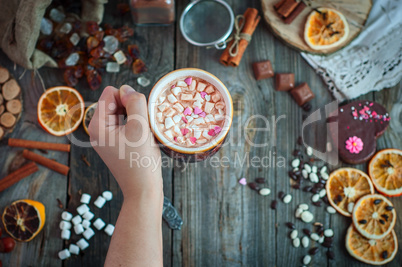 human hand holds a mug with a drink