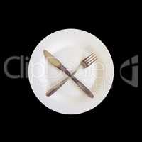 knife and fork on the plate isolated on the black