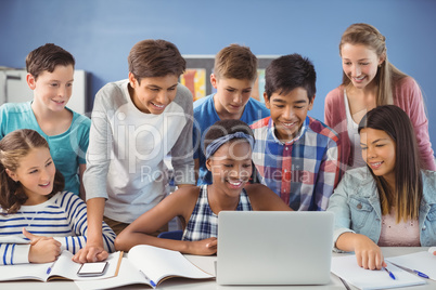 Group of students using laptop in classroom