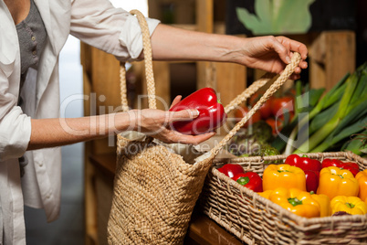 Woman buying bell pepper at organic section
