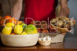 Staff holding a bowl of kiwi at counter in market