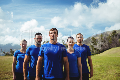 Group of fit people posing together in boot camp