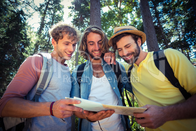 Friends looking at map in forest