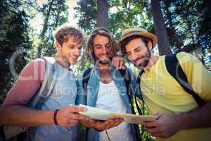 Friends looking at map in forest
