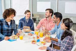 Happy executives interacting while having breakfast