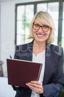 Businesswoman writing on diary in a restaurant