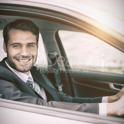 Man sitting in a car smiling and looking at camera
