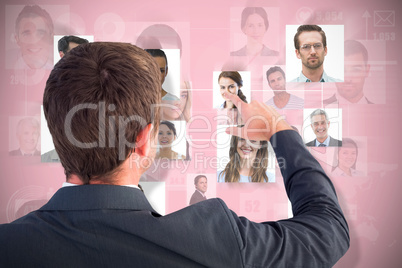 Composite image of businessman pointing with his finger