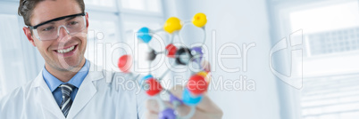 Composite image of happy scientist experimenting molecule structure