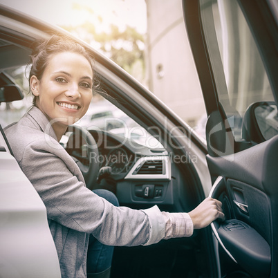 Woman sitting in a car and smiling at camera