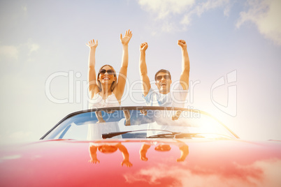 Crazy couple standing in red cabriolet