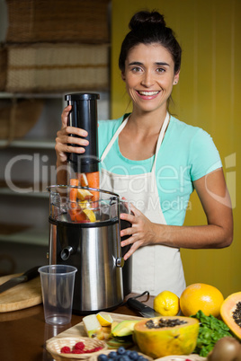 Portrait of smiling shop assistant preparing juice