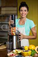 Portrait of smiling shop assistant preparing juice