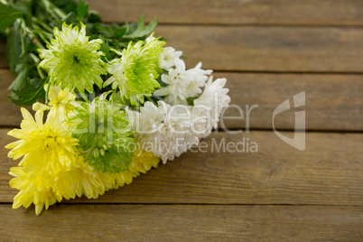 Bunch of yellow flowers on wooden plank