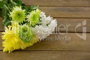 Bunch of yellow flowers on wooden plank