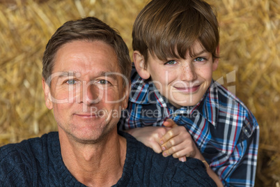Happy Father Son Man and Boy Smiling on Hay Bales