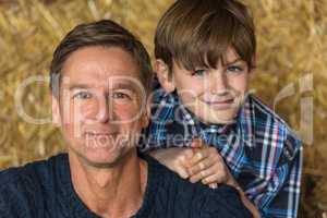 Happy Father Son Man and Boy Smiling on Hay Bales
