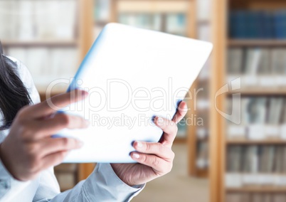 Womans hands holding tablet in Library