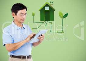 Man with tablet and green house graphic against green background