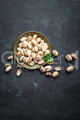 Pistachios nuts on dark background, top view, healthy snack