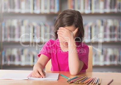 Sad girl at desk against bookshelves