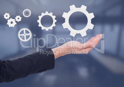 Open palm business hand in front of blue room with settings cogs icons