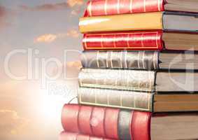Books stacked by sun clouds