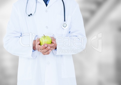 Doctor mid section with apple against blurry background