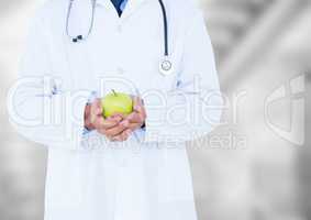 Doctor mid section with apple against blurry background