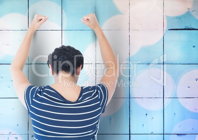 Sad angry woman grief banging fists against a blue wall