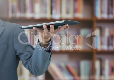 mans hand holding tablet in Library