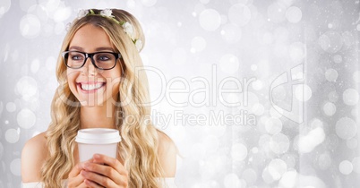 Woman with flowers in hair and white coffee cup against white bokeh