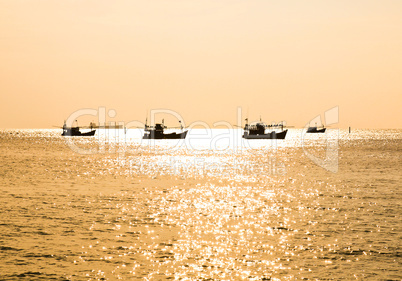 Fishing boat silhouette at sunset in sea