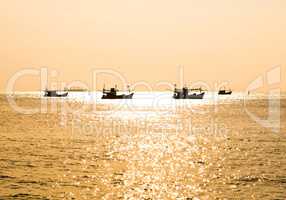Fishing boat silhouette at sunset in sea