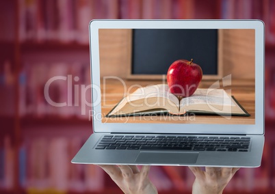Hands with laptop showing book with red apple against blurry bookshelf with red overlay