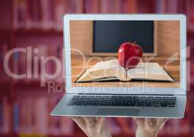 Hands with laptop showing book with red apple against blurry bookshelf with red overlay