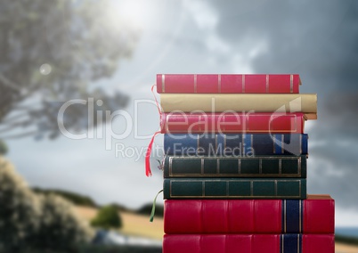 Books stacked by romantic nature landscape