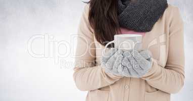 Woman mid section holding polka dot mug against white wall