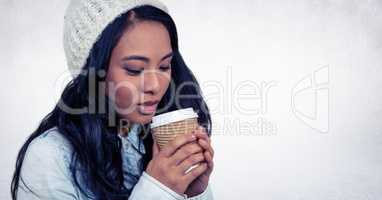 Close up of woman drinking from coffee cup against white wall