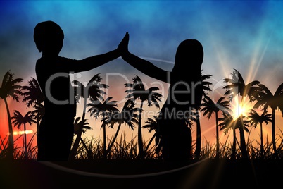 Silhouettes of  kids  against sunset view with palm trees
