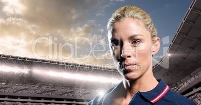 Woman in polo shirt in stadium with bright lights and sky with clouds